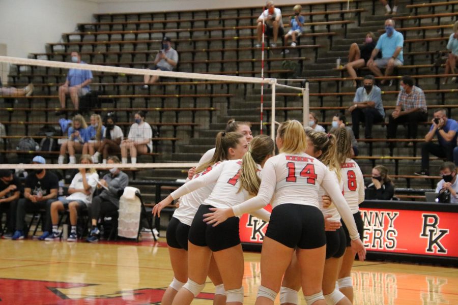 The team huddles together after scoring a point. 