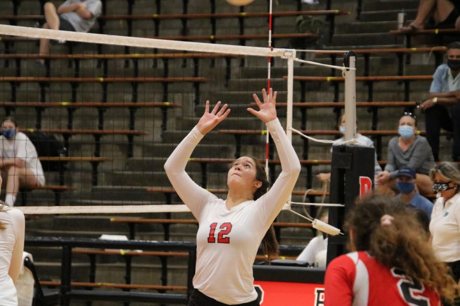 Junior Alexis Chin sets the ball to be spiked.