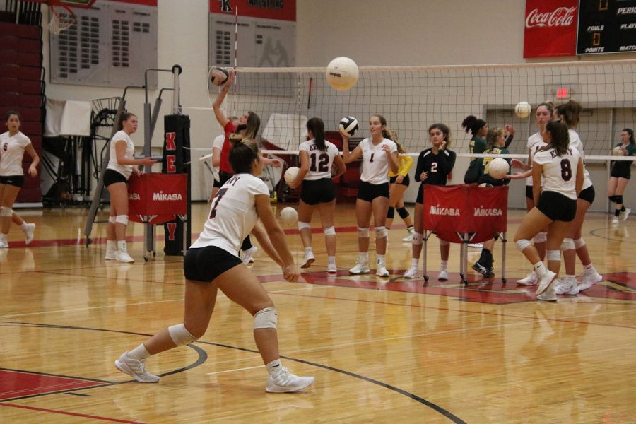 Junior Isabella Miller goes up to bump the ball during warmup.