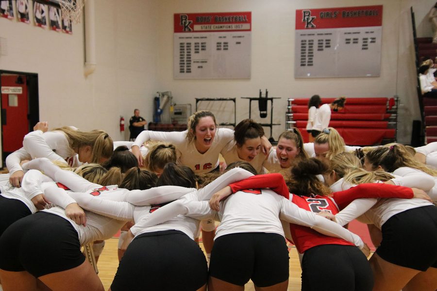 In a pre-game huddle, the Varsity team yells with joy.
