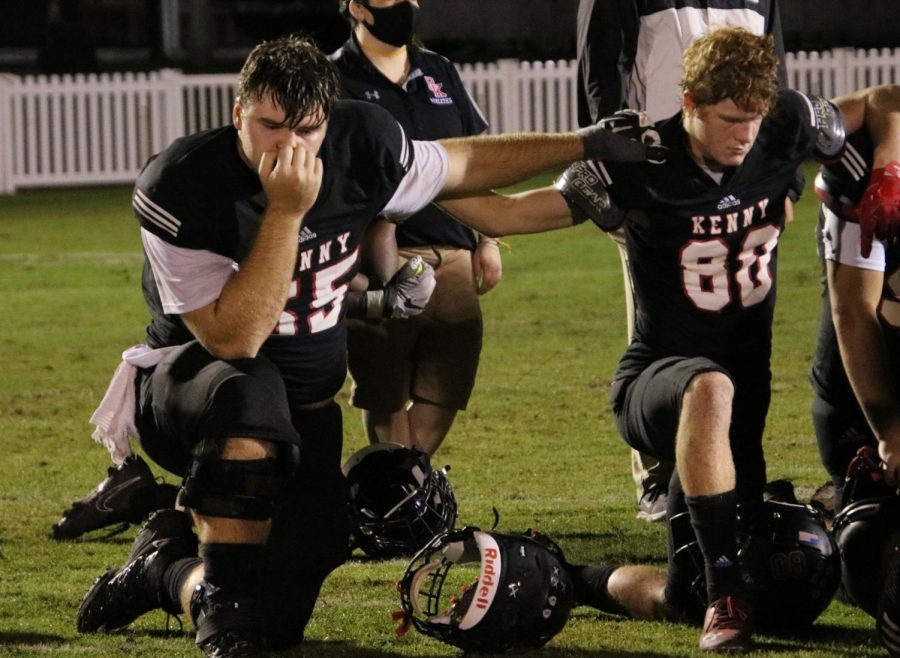 Senior Micheal Myslinski taking a knee during the after game pep talk from Coach Time Krause. 