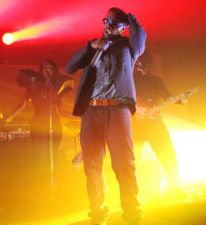 Kanye West preforming on stage in front of people.