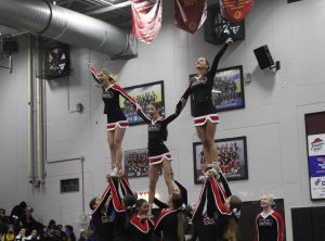 Sophomore Brooke Curry, Freshman Sheridan Delegal and Senior Delaney Porazinski fly in the pyramid.