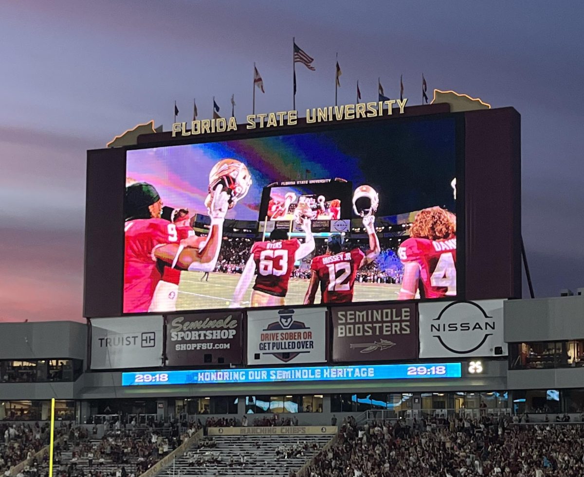 The Seminole players shows unity by putting their helmets together in the air.