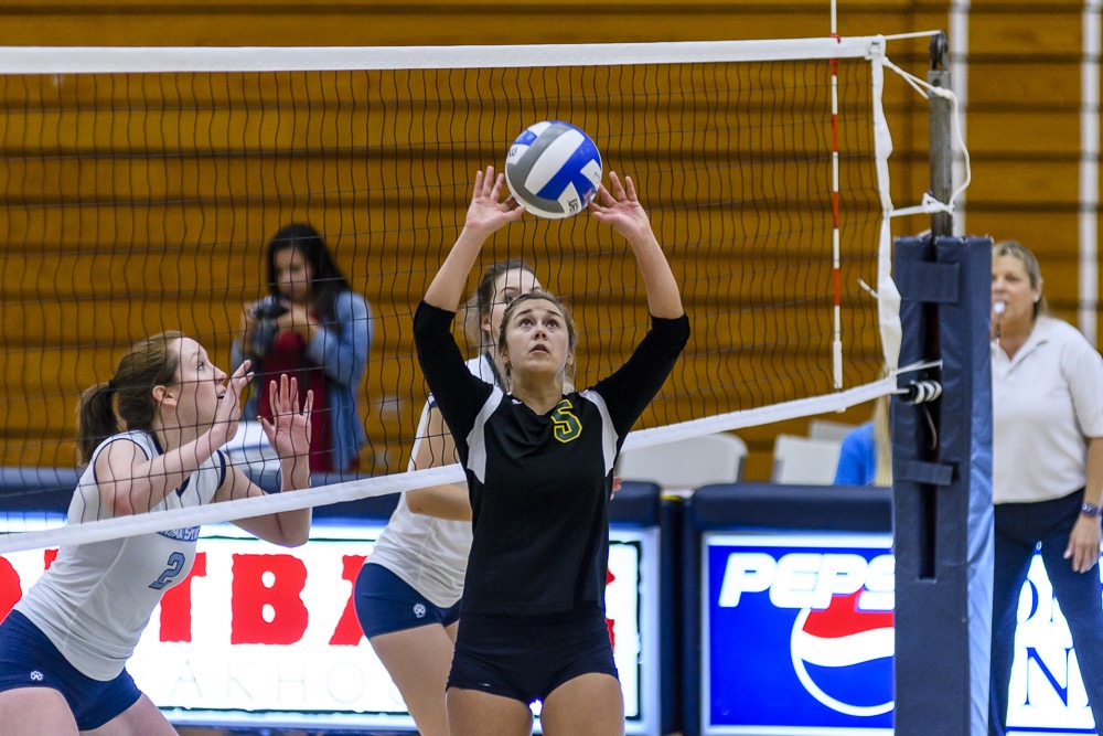 Player sets the ball to her teammate.
