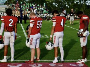 Senior captains Gunnar Rogers, Robert Measor, Gavin Hawkins and James Davis (left to right) stand for the pregame prayer on Friday August 15, against the Suwannee Bulldogs. 