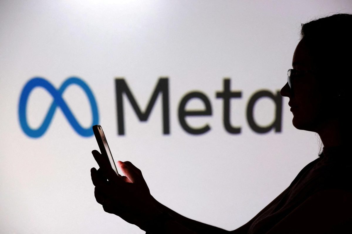A teenager poses for a photo while holding a smartphone in front of a Meta logo in this illustration taken September 11, 2025. REUTERS/Dado Ruvic/Illustration