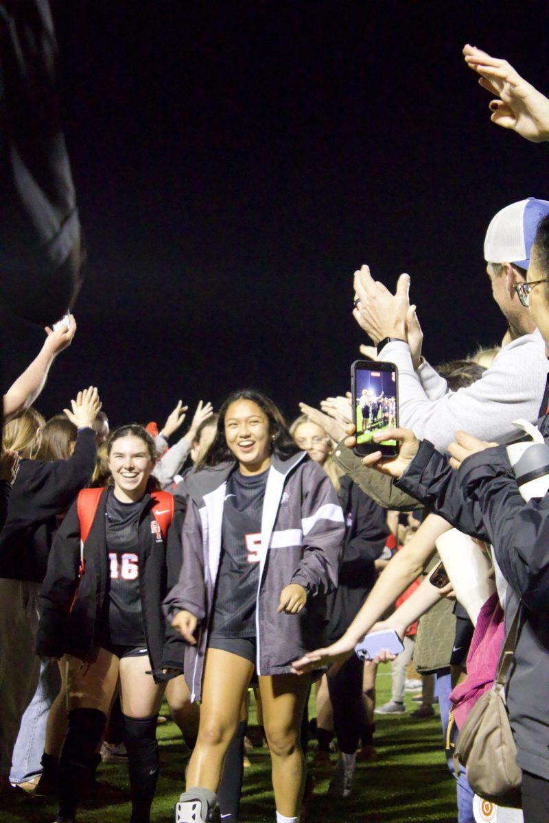 Seniors Olivia Pia and Kylie Morgan walk through the human tunnel after the regional final game against the Vanguard Knights on Tuesday, February 17.