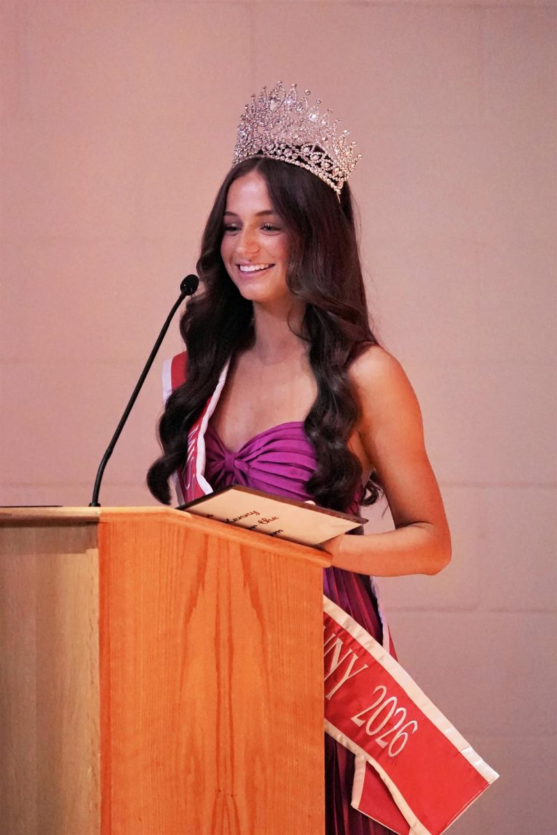 Welcoming the crowd, Miss BK 2026 Sheridan Delegal prepares to pass on the crown.