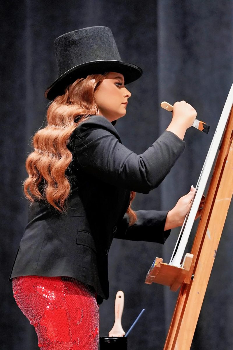 Rebekah Jones, whose talent was speed painting, looks intently at her canvas. 
