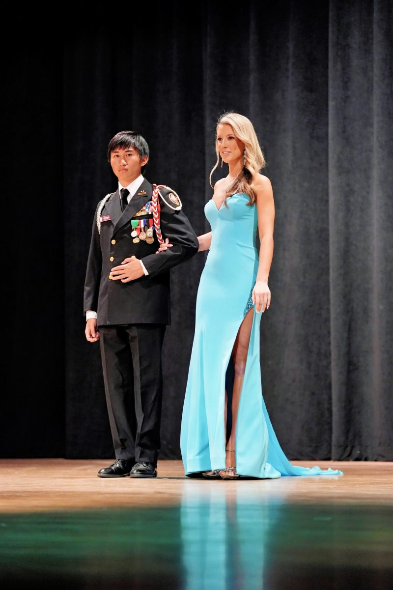 Contestant #7, Sophie Isaac, is escorted by NJROTC cadet Miguel Fernandez during the formalwear portion of the pageant. 