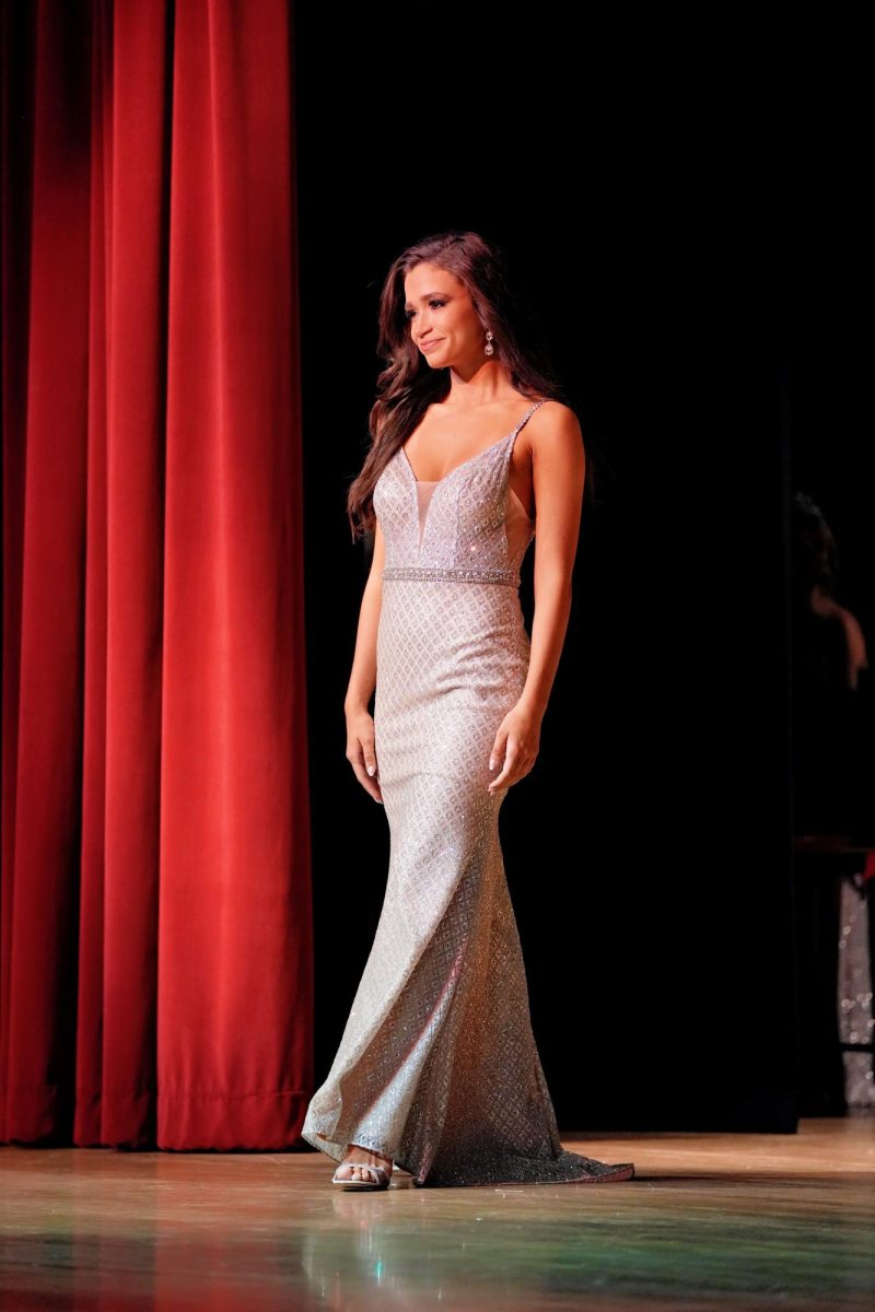 Against the backdrop of the curtains, Scarlett Gibbs models her glittering gown.